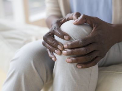 woman holding knee due to knee pain