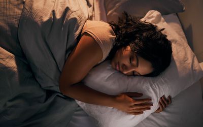 High angle shot of a young woman sleeping in bed