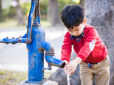 Asian boy learning to wash his hands