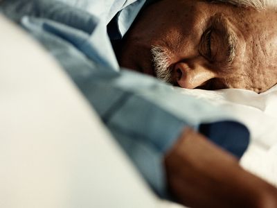 Mature man asleep on bed, close up