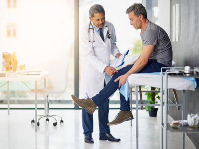 Doctor examines patient's knee.