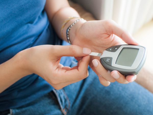 A young woman using a glucose meter 