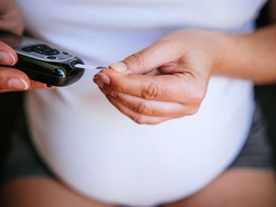 Pregnant person testing blood sugar 