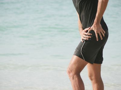 A person feels hip pain when walking at the beach