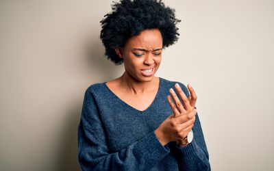 woman suffering pain on hands and fingers