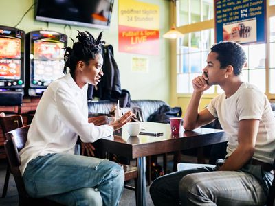 Couple Of Friends Talking And Drinking Coffee At Pool Hall