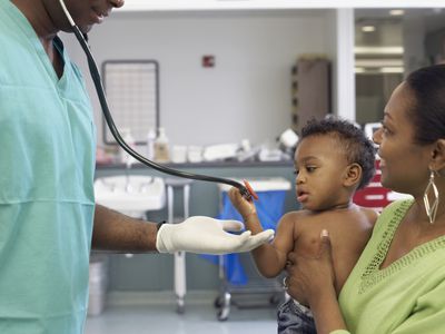 African American doctor talking to mother and baby