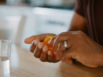 Black American man with vial of prescription pills and water