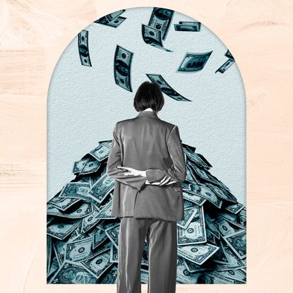 Woman in a suit looking at a pile of money as more falls from the sky