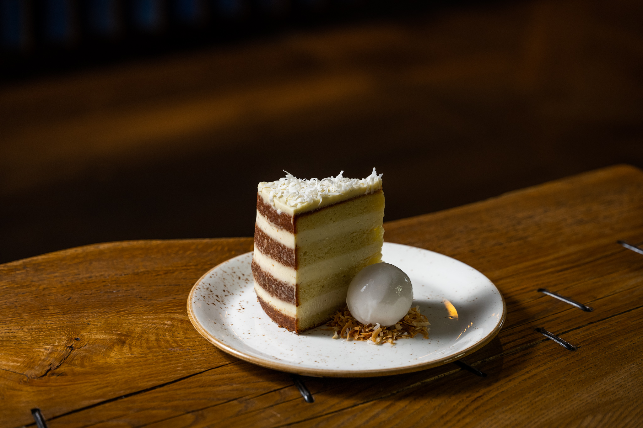 A slice of coconut cake with ice cream.