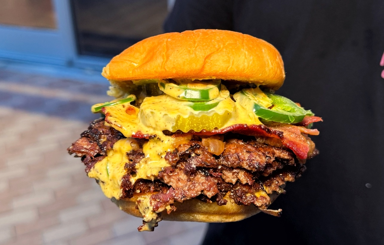 A double-patty smash burger dripping with sauce