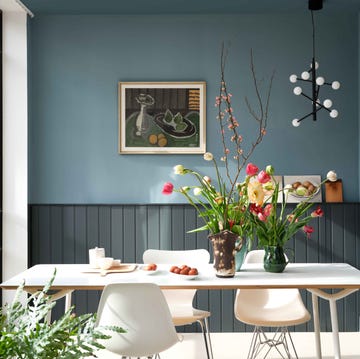 a living room with table chairs and a blue wall