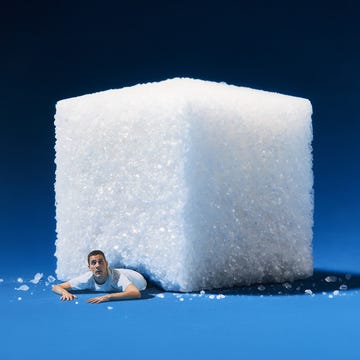 a large sugar cube with a person emerging from underneath it