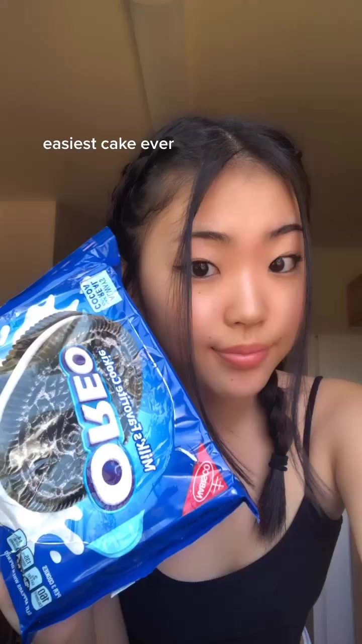 a woman holding up a bag of oreo cookies