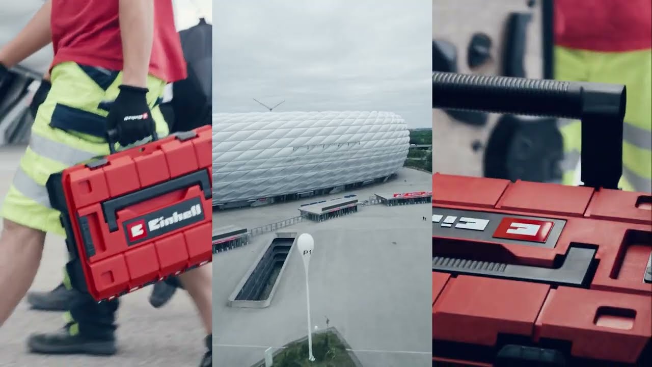 A worker carries a red Einhell toolbox outside the Allianz Arena, showcasing the partnership between Einhell and FC Bayern Munich.