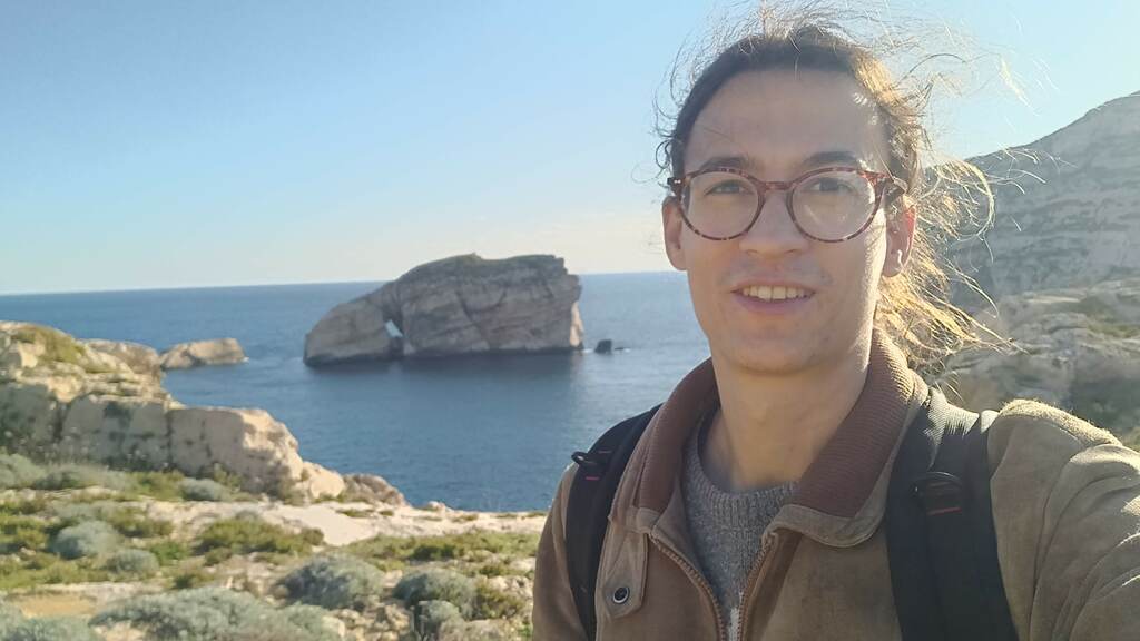A landscape photo of Joaquim de Souza outdoors by the sea.