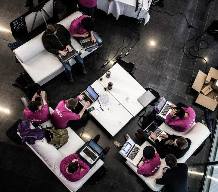 Foto desde lo alto de un equipo de Odoo trabajando en sus ordenadores